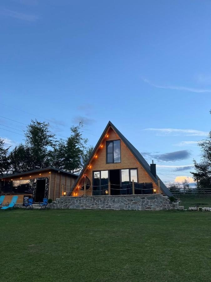 Cabana și foișorul seara, cu luminile aprinse